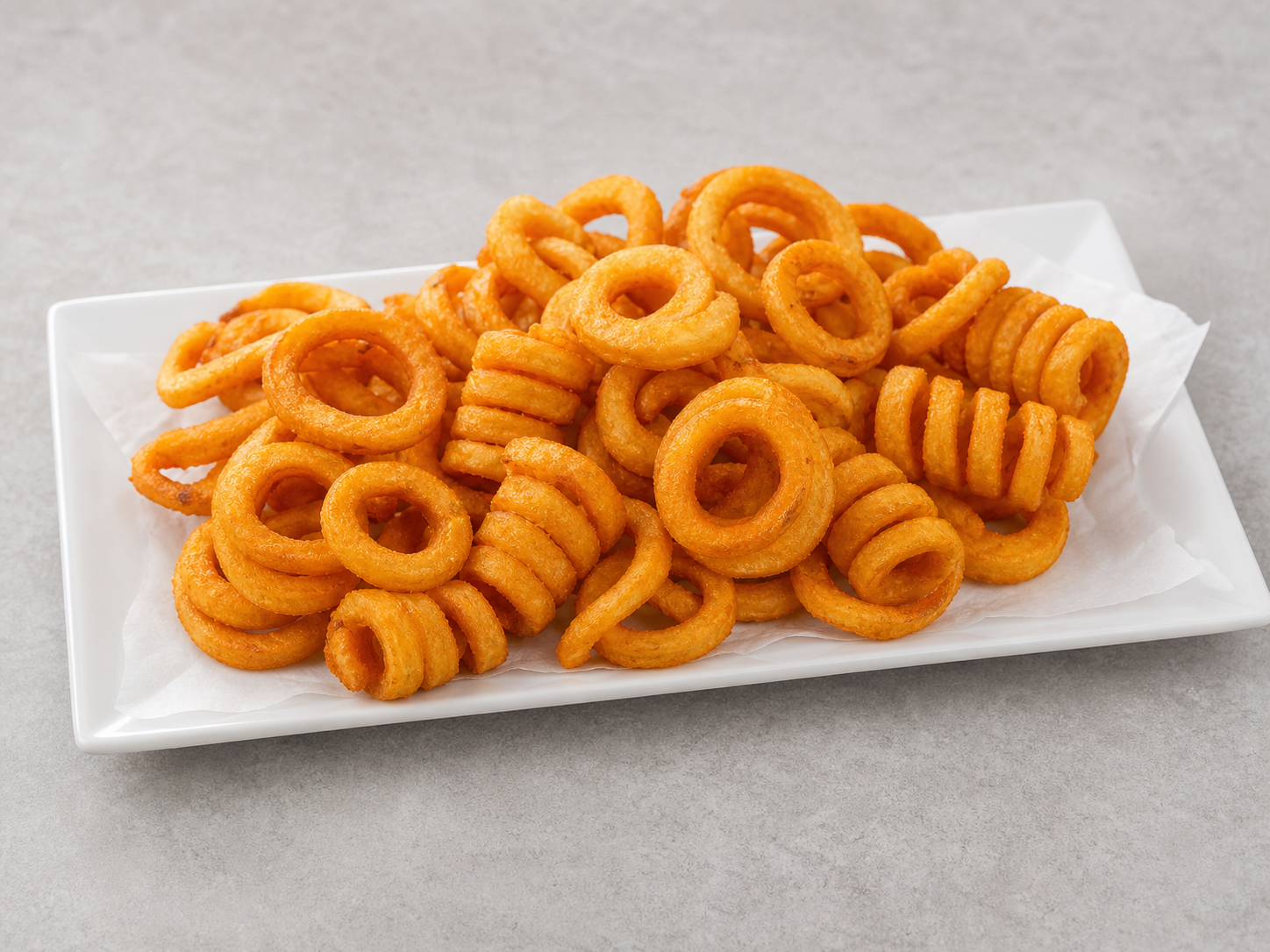 Golden frozen curly fries with complete curls and varied arcs